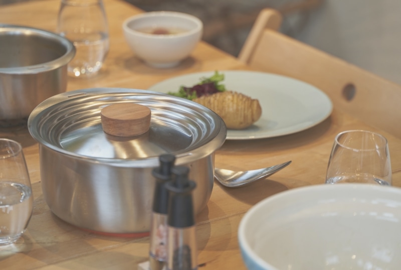 テーブルに置かれた鍋と食器の写真